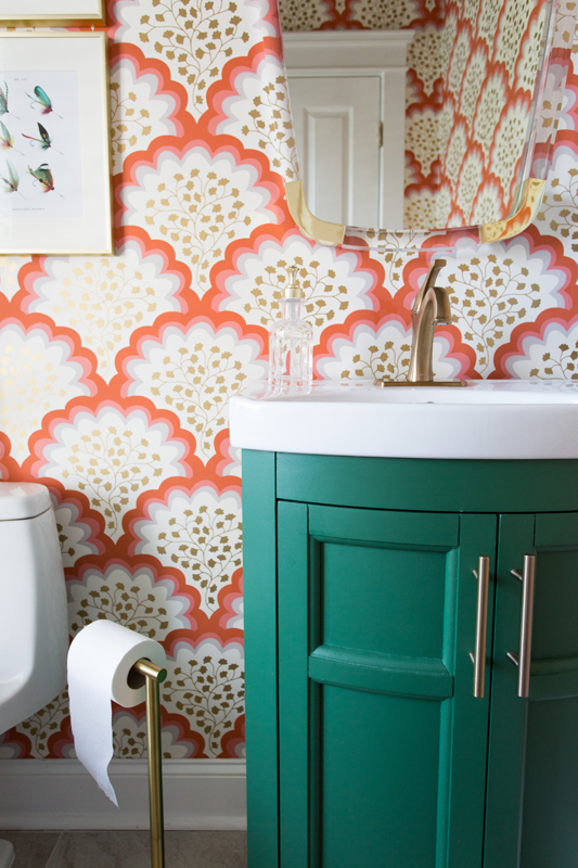 Wallpapered bathroom with kelly green vanity in maximalism interior design style