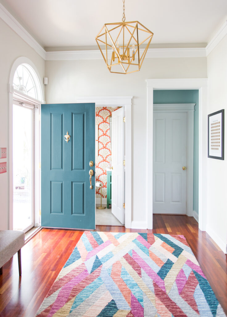 Entryway with geometric rug and art deco light fixture
