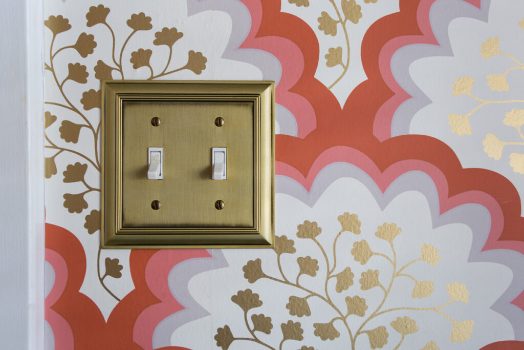 A picture of a light switch and fancy wallpaper behind it